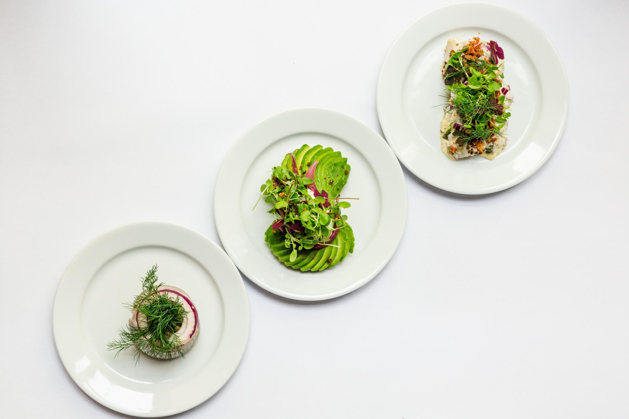 Set of three plated dishes on neutral background